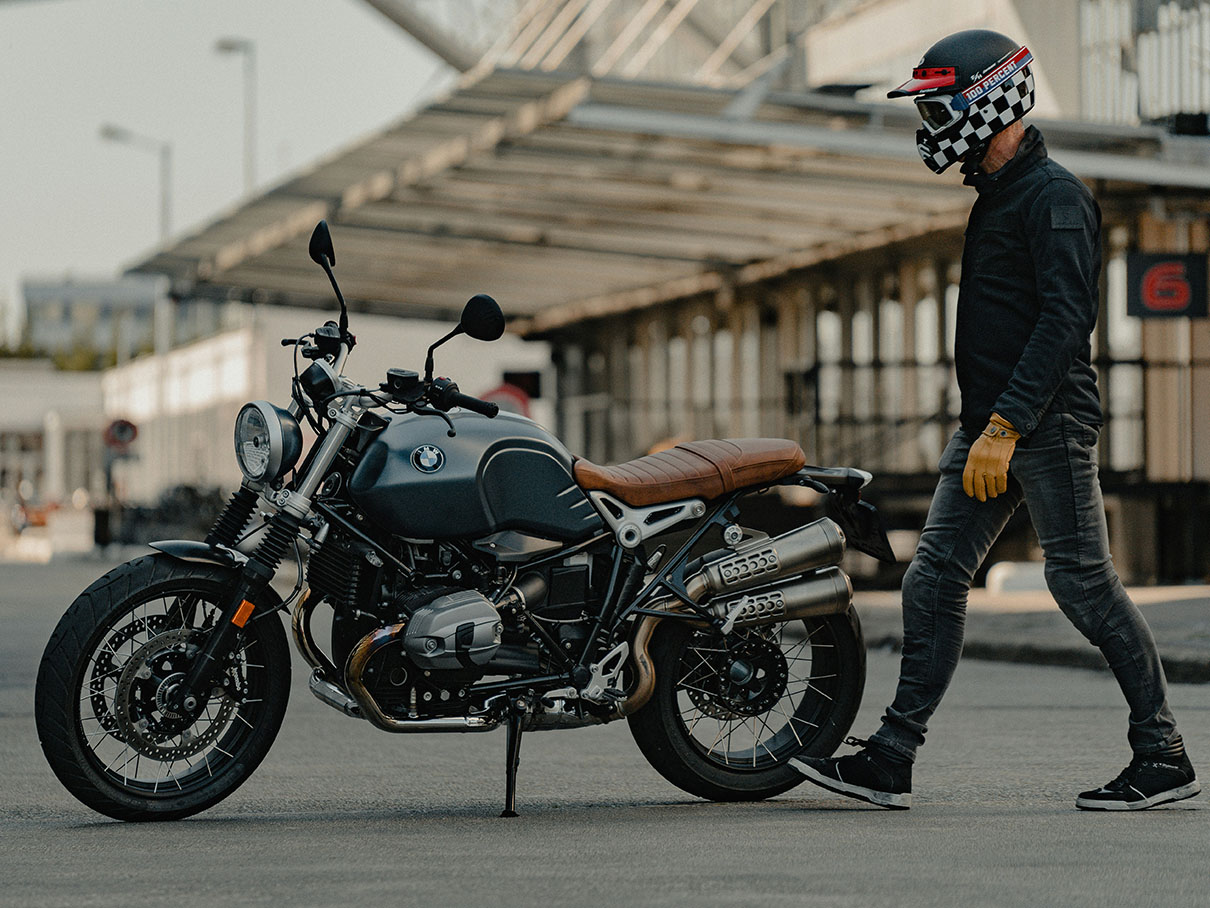 A man approaches a motorcycle, ready to ride.